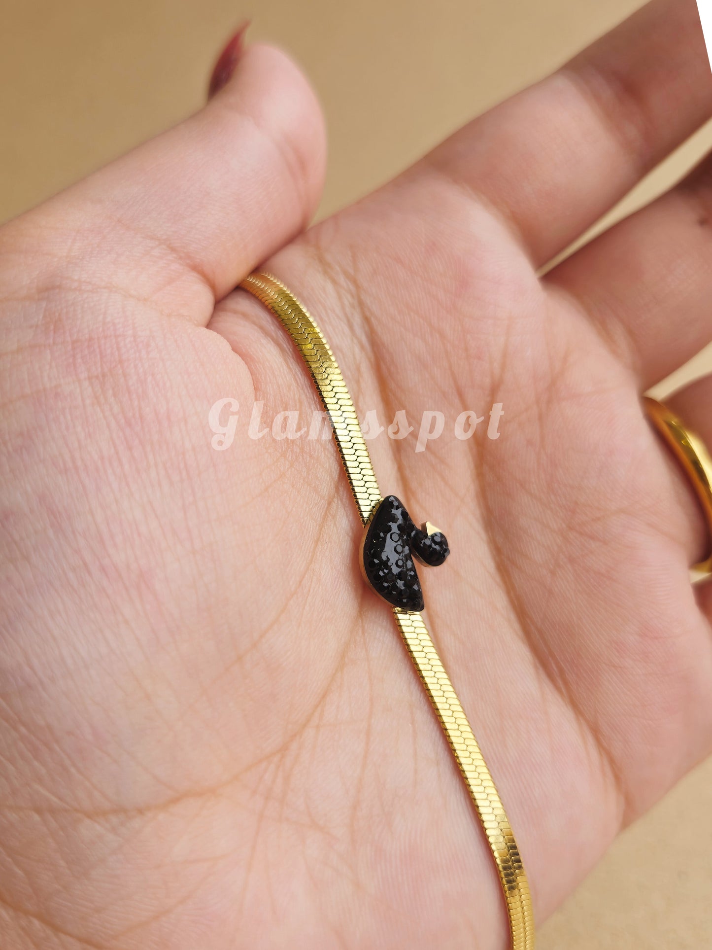 Black Swan Bracelet with a black charm on a hand, brand 'Glamaspot' visible.