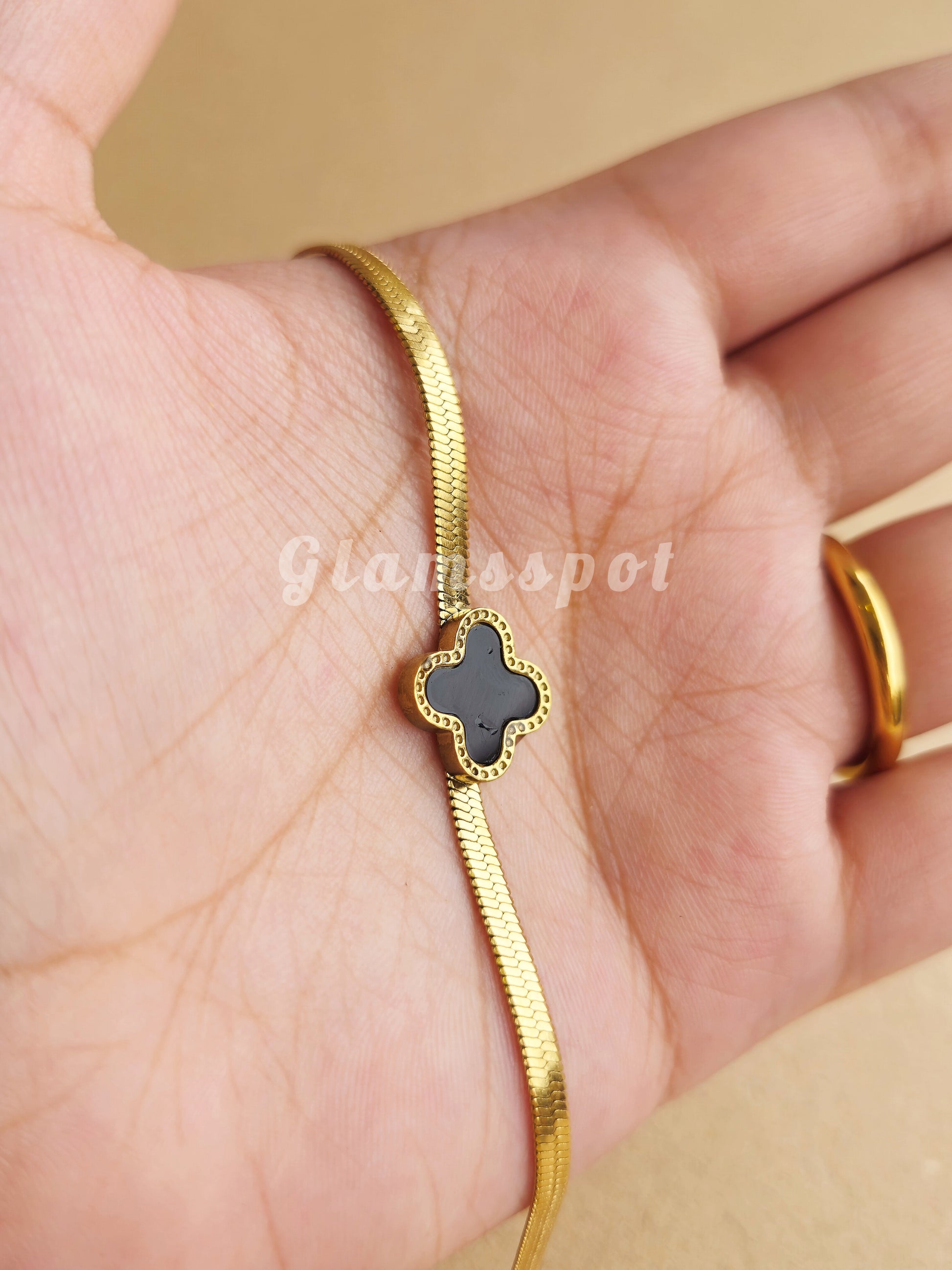 Black Vancleef Bracelet with a black clover charm on a hand, brand 'Gianospot' visible.
