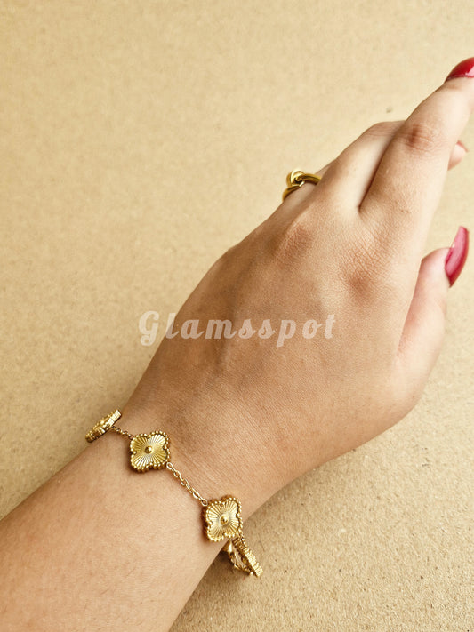Gold Golden Clover Bracelet on a wrist with a beige background