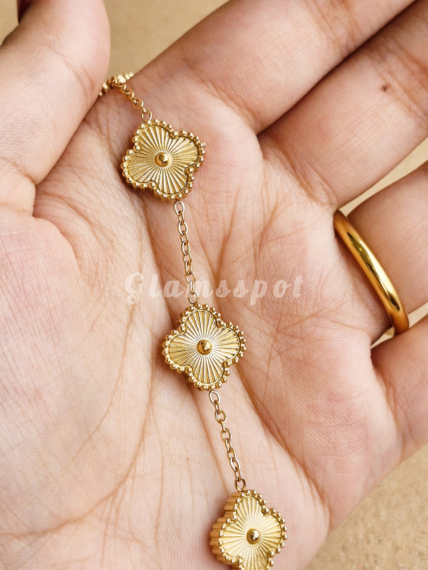 Golden Clover Bracelet floral designs held in a hand