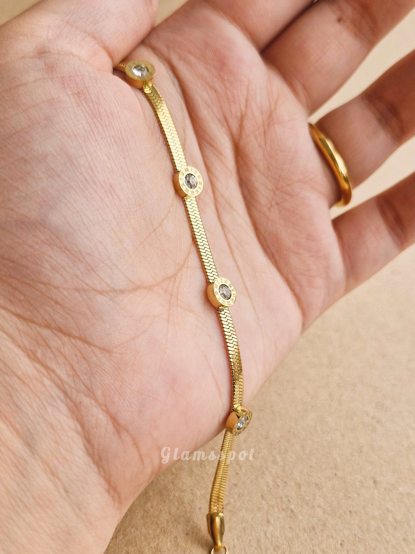 Gold Roman Bracelet on a hand with a beige background