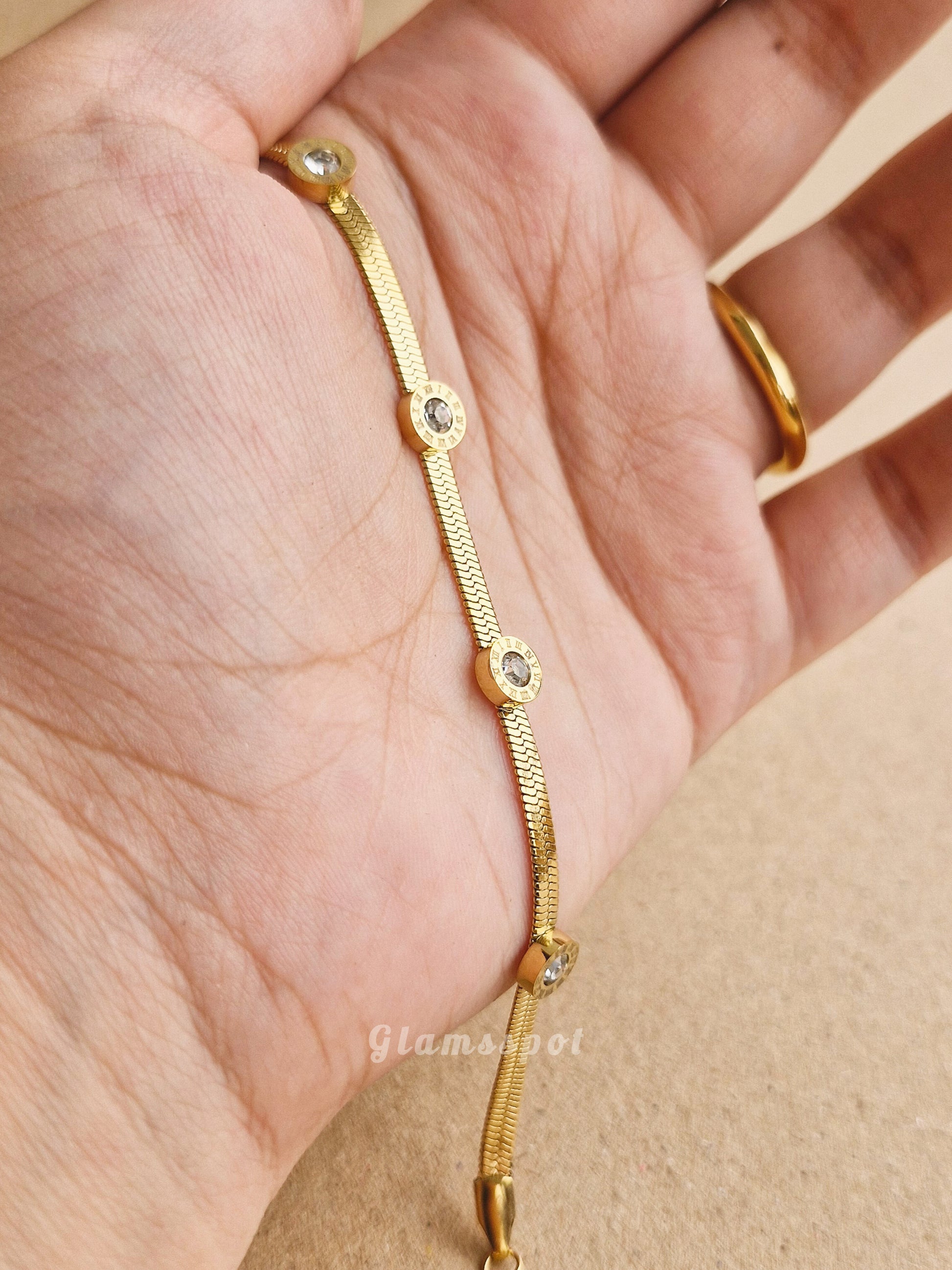 Gold Roman Bracelet on a hand with a beige background